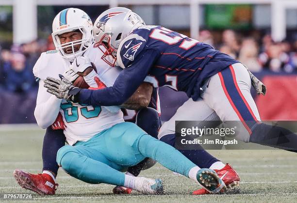 Elandon Roberts of the New England Patriots tackles Julius Thomas of the Miami Dolphins during the third quarter of a game at Gillette Stadium on...