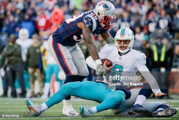Trey Flowers and Marquis Flowers of the New England Patriots tackle Matt Moore of the Miami Dolphins during the third quarter of a game at Gillette...