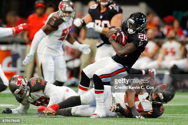 Tevin Coleman of the Atlanta Falcons is tackled by Gerald McCoy of the Tampa Bay Buccaneers during the second half at Mercedes-Benz Stadium on...