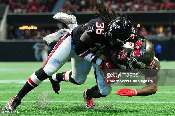 Kemal Ishmael of the Atlanta Falcons tackles Peyton Barber of the Tampa Bay Buccaneers short of the end zone during the second half at Mercedes-Benz...