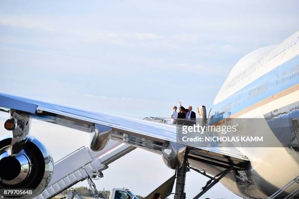 President Donald Trump waves with his wife Melania and son Barron as they board Air Force 1 in Palm Beach, Florida on November 26, 2017 on their way...