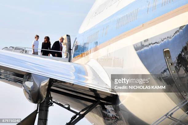President Donald Trump, his wife Melania and son Barron, board Air Force 1 in Palm Beach, Florida on November 26, 2017 on their way to Washington DC....