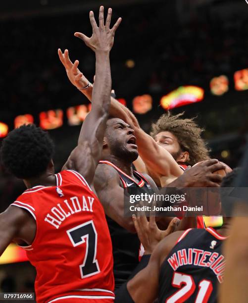 Dion Waiters of the Miami Heat drives between Justin Holiday and Robin Lopez of the Chicago Bulls at the United Center on November 26, 2017 in...