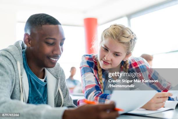 students discussing paper in classroom at school - classroom discussion stock pictures, royalty-free photos & images