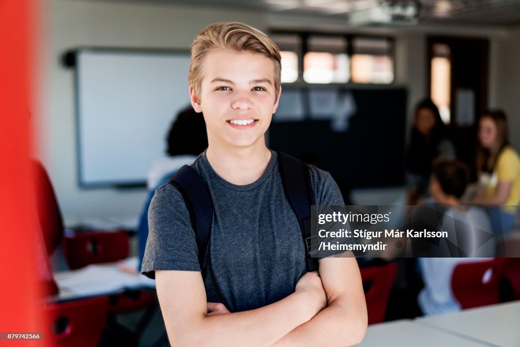 Blonde tiener glimlachen met gekruiste armen