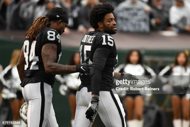 Michael Crabtree of the Oakland Raiders is walked off the field by Cordarrelle Patterson after being ejected for fighting with Aqib Talib of the...