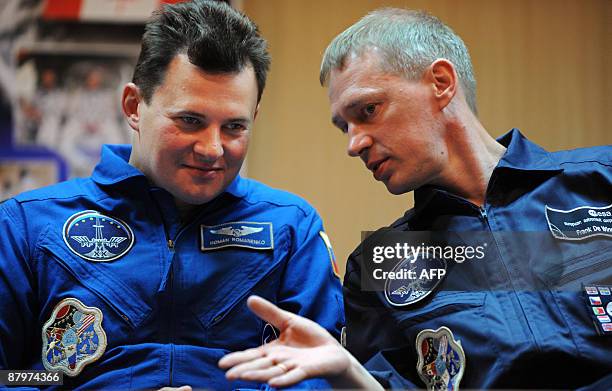 European Space Agency astronaut Frank De Winne of Belgium and Russian cosmonaut Roman Romanenko chat during a press conference at the Russian leased...