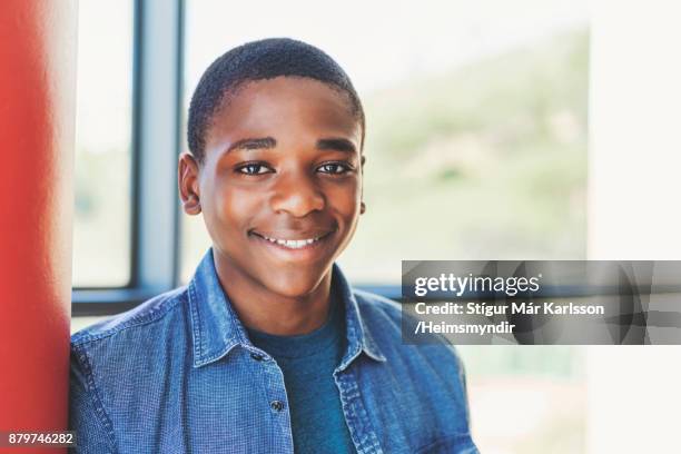 close-up of smiling teenage boy by red column - open day 14 stock pictures, royalty-free photos & images