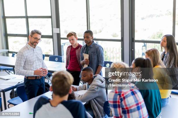 multi-ethnic students discussing with professor - male lecturer standing in front of a classroom stock pictures, royalty-free photos & images