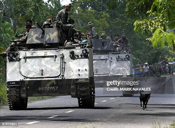 Philippine Army armoured personnel carriers and trucks move down a highway of the town of Datu Piang after separatist Moro Islamic Liberation Front...