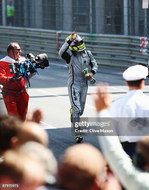 Jenson Button of Great Britain and Brawn GP runs back to the podium after winning the Monaco Formula One Grand Prix at the Monte Carlo Circuit on May...