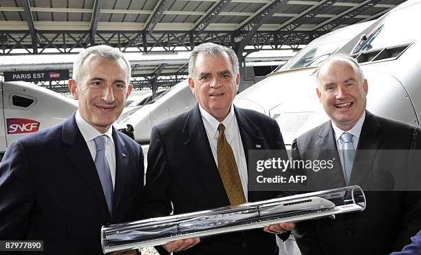 Transportation secretary Ray Lahood holds a model of a French high speed train TGV next to head of state-owned SNCF railway company Guillaume Pepy...