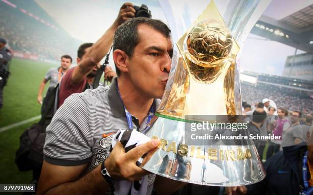 Fabio Carille of Corinthians celebrates with the trophy after Corinthians win the Brasileirao 2017 after the match against Atletico MG for the...