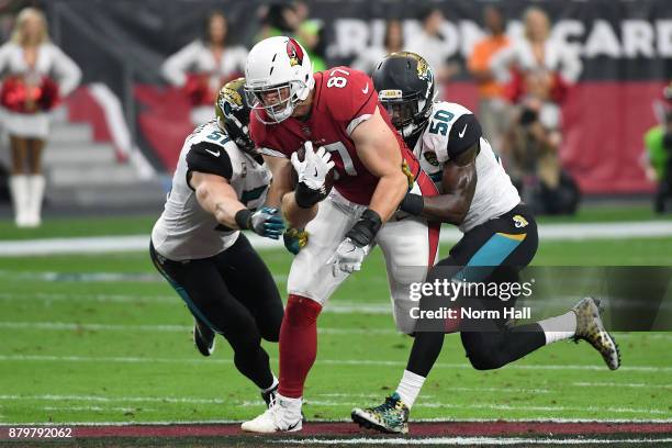 Troy Niklas of the Arizona Cardinals runs with the football against Paul Posluszny and Telvin Smith of the Jacksonville Jaguars in the first half at...