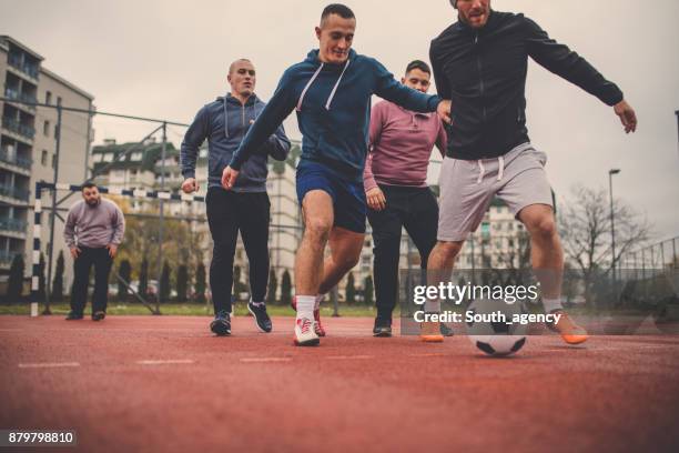 playing soccer outdoors - street running stock pictures, royalty-free photos & images