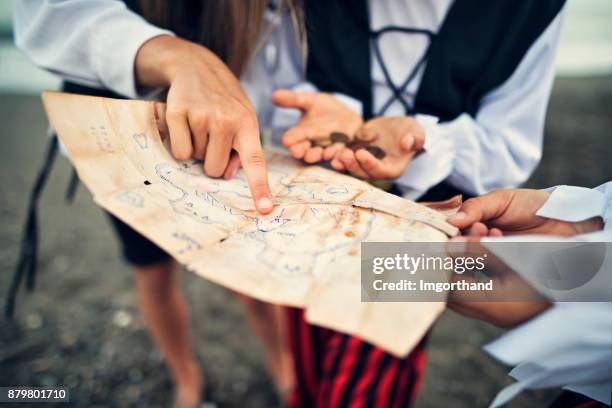 kids pirates reading treasure map on a beach - coin map stock pictures, royalty-free photos & images