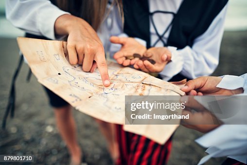 Kids pirates reading treasure map on a beach Kids pirates reading treasure map on a beach