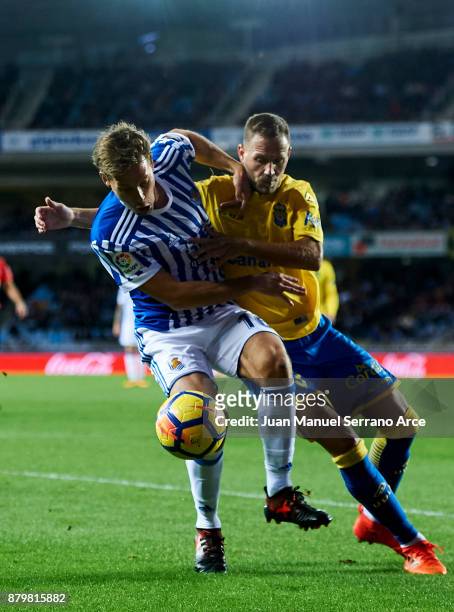 Dani Castellano of UD Las Palmas duels for the ball with Sergio Canales of Real Sociedad during the La Liga match between Real Sociedad de Futbol and...