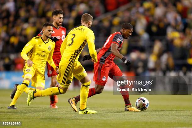 Armando Cooper of the Toronto FC dribbles the ball away from Josh Williams of the Columbus Crew SC and Artur of the Columbus Crew SC during the match...