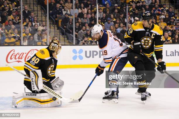 Patrick Maroon of the Edmonton Oilers watches the loose puck against Tuukka Rask and Zdeno Chara of the Boston Bruins at the TD Garden on November...