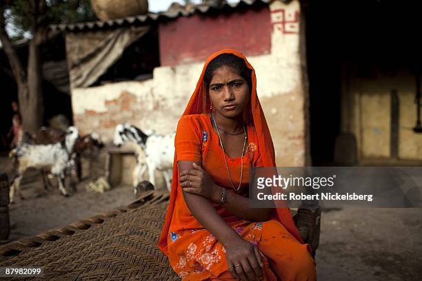 Young girl sits in a yard of a slum area near a newly dug roadway April 21, 2009 where agricultural areas she and members of twelve families have...