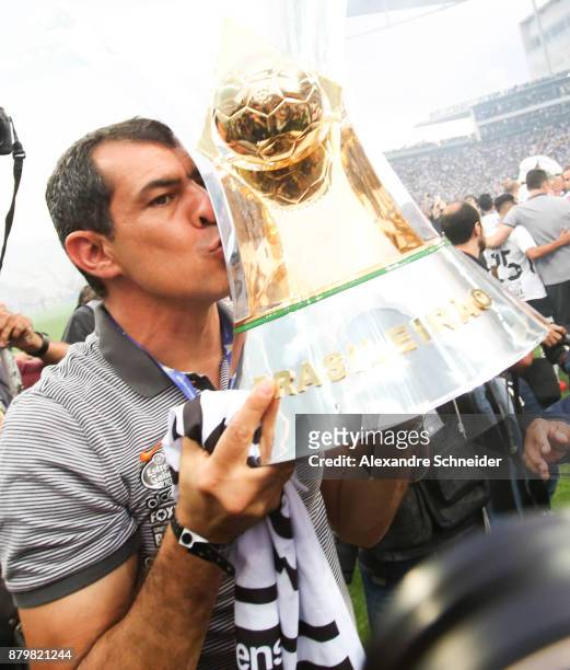 Fabio Carille headcoach of Corinthians celebrates with the trophy after Corinthians win the Brasileirao 2017 after the match against Atletico MG for...