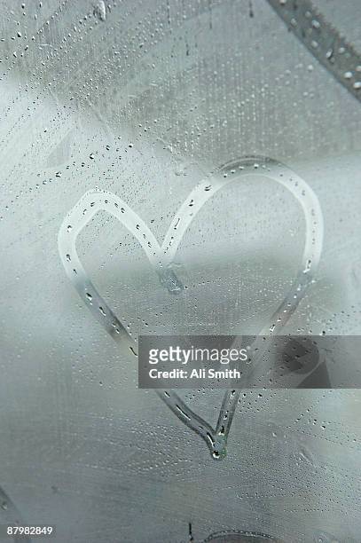 heart drawn on fogged window - mirror steam fotografías e imágenes de stock