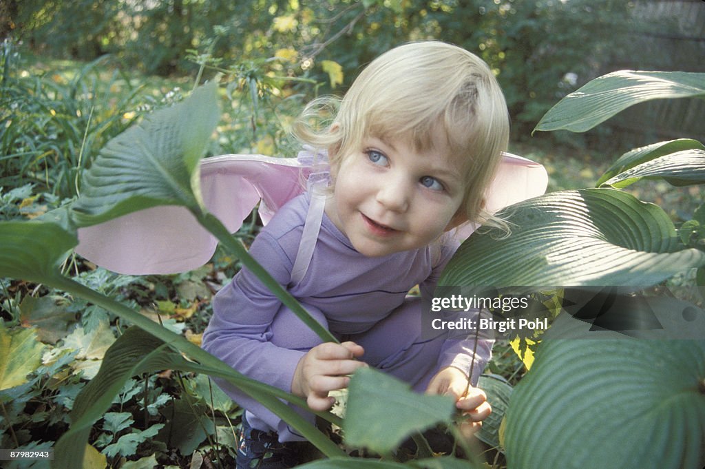 Girl hiding behind plant