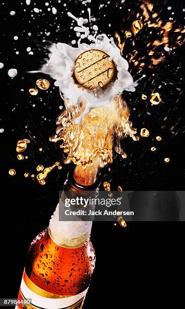 beer bottle cap bursting with splashing beer - liquid explosion stock-fotos und bilder