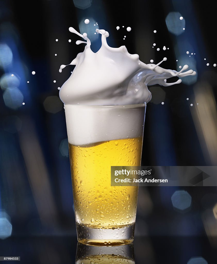 Glass of beer with splashing foam