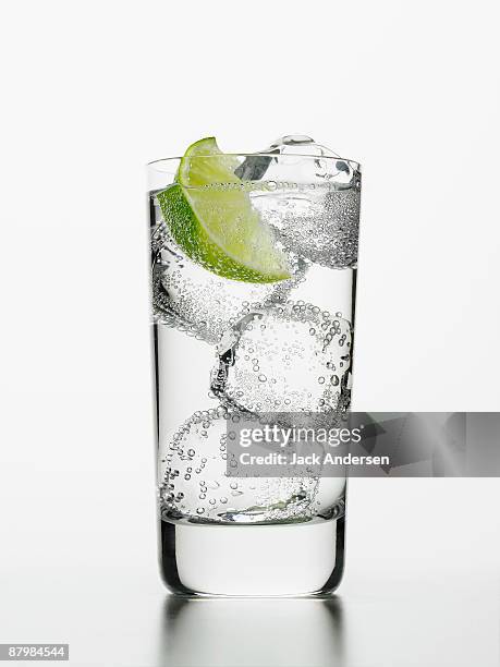 seltzer water with lime wedge - sparkling water glass stock-fotos und bilder