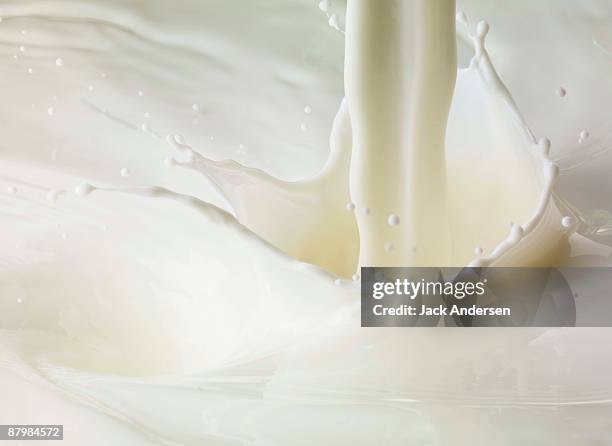 milk pour and splash - pouring fotografías e imágenes de stock