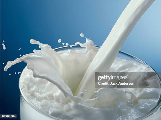 glass of milk pouring - melkprodukt stockfoto's en -beelden