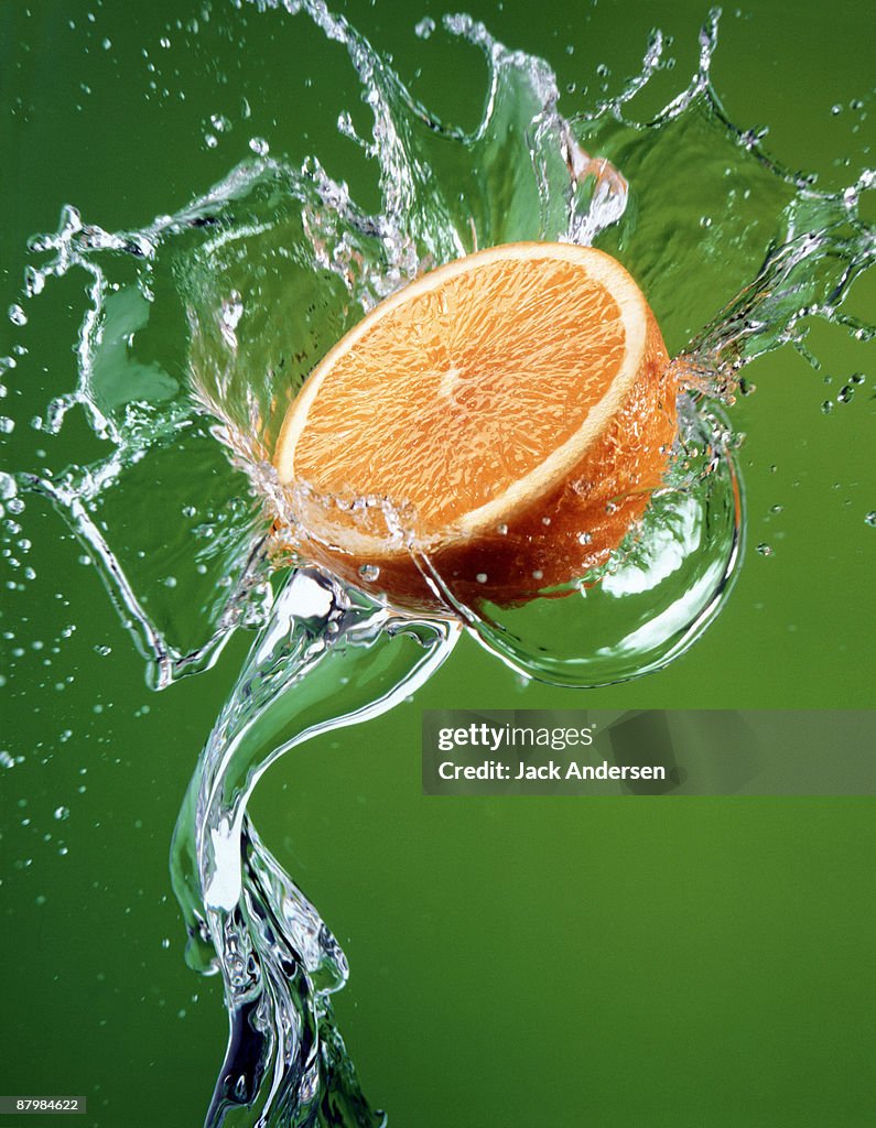 Orange half splashing in water