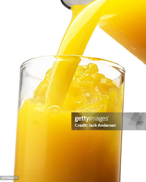 orange juice pour - pouring softdrink stock-fotos und bilder