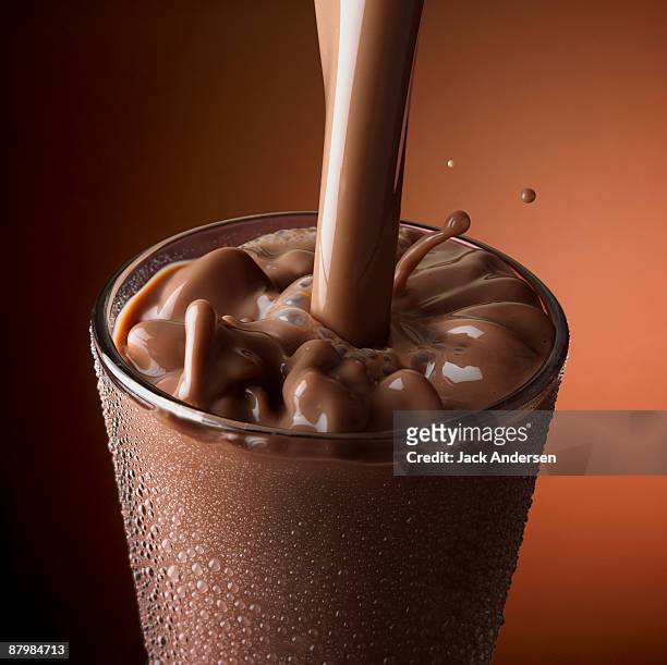 chocolate milk pouring into glass - chocolate milkshake stock pictures, royalty-free photos & images