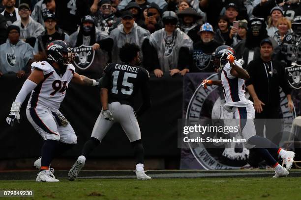 Michael Crabtree of the Oakland Raiders fights with Aqib Talib of the Denver Broncos during the first quarter their NFL football game at...