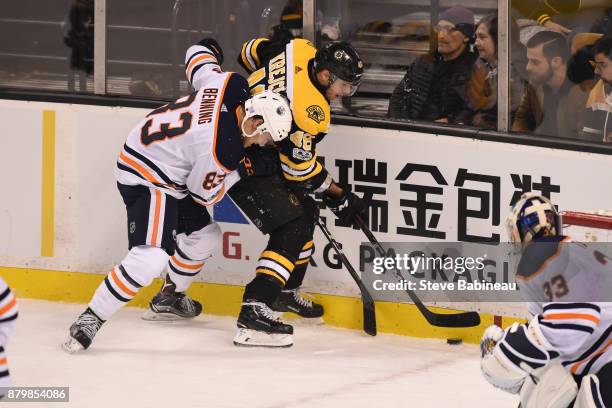 David Krejci of the Boston Bruins fight for the puck against Matt Benning of the Edmonton Oilers at the TD Garden on November 26, 2017 in Boston,...