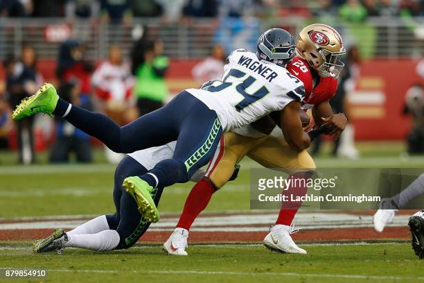 Carlos Hyde of the San Francisco 49ers is tackled by Bobby Wagner of the Seattle Seahawks at Levi's Stadium on November 26, 2017 in Santa Clara,...