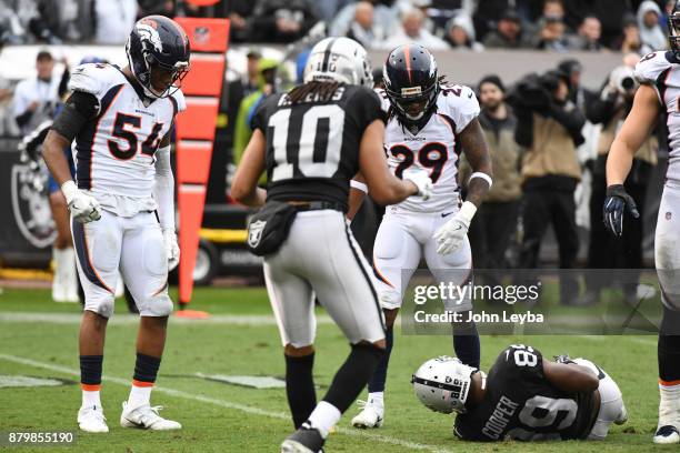 Denver Broncos free safety Bradley Roby stands over Oakland Raiders wide receiver Amari Cooper as he lays motionless after a hit by Denver Broncos...