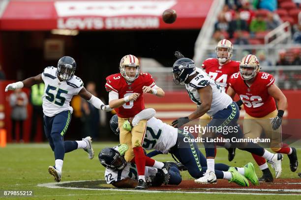 Beathard of the San Francisco 49ers is tackled by Michael Bennett and Nazair Jones of the Seattle Seahawks at Levi's Stadium on November 26, 2017 in...