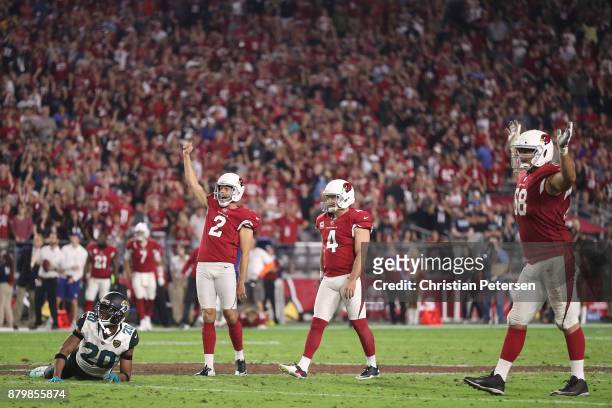 Andy Lee, Phil Dawson and Jared Veldheer of the Arizona Cardinals celebrate after Dawson scores a 57 yard game winning field goal against the...