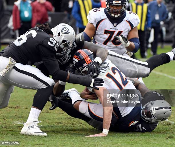 Oakland Raiders outside linebacker Bruce Irvin defensive end Mario Edwards and defensive end Denico Autry sack Denver Broncos quarterback Paxton...