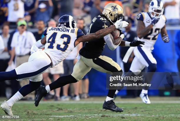 John Johnson of the Los Angeles Rams tackles Alvin Kamara of the New Orleans Saints during the NFL game at the Los Angeles Memorial Coliseum on...