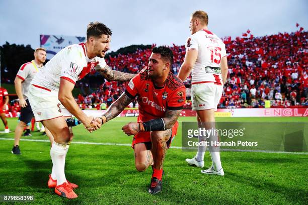 Gareth Widdop of England helps Andrew Fifita of Tonga of Tonga his feet during the 2017 Rugby League World Cup Semi Final match between Tonga and...