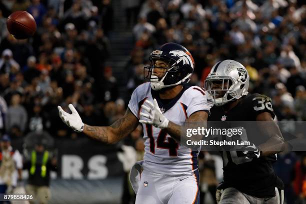 Cody Latimer of the Denver Broncos makes a catch as TJ Carrie of the Oakland Raiders defends during the fourth quarter of their NFL football game at...