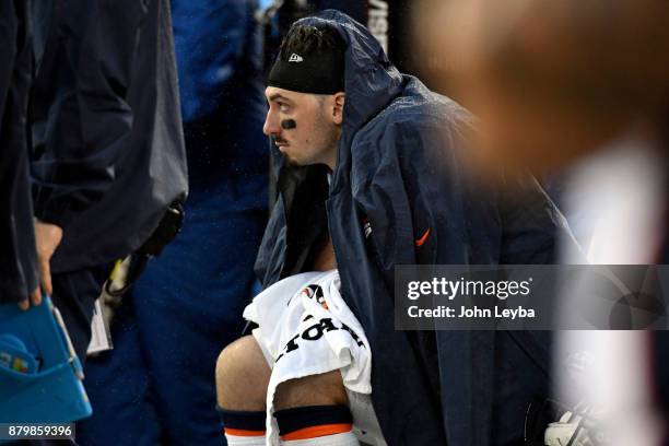 Denver Broncos training staff looks over quarterback Paxton Lynch sits dejected on the bench in the fourth quarter against the Oakland Raiders on...