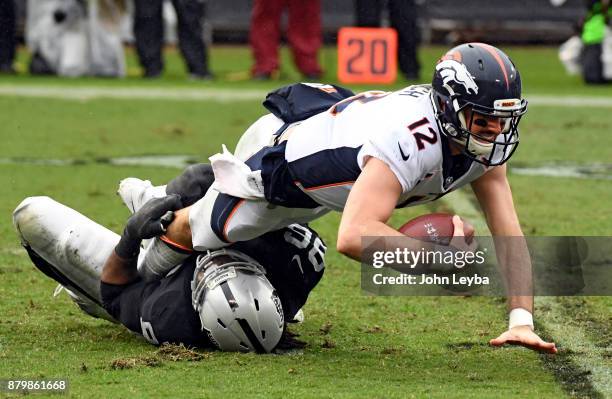 Denver Broncos quarterback Paxton Lynch gets sacked by Oakland Raiders defensive end Denico Autry during the second quarter on November 26, 2017 in...