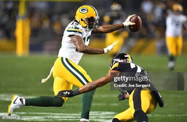 Davante Adams of the Green Bay Packers uses a stiff arm to evade a tackle attempt by Mike Mitchell of the Pittsburgh Steelers in the second half...