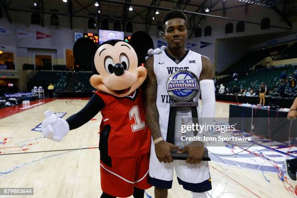 Orlando, FL West Virginia Mountaineers guard Daxter Miles Jr. Holding the championship trophy poses for a photo with Mickey Mouse the AdvoCare...